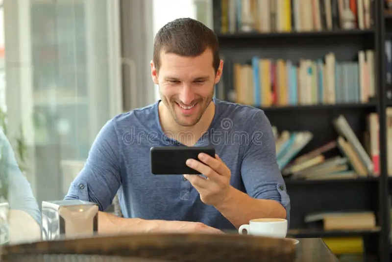 Menikmati Drama Thailand di Smartphone Seseorang menonton drama di smartphone